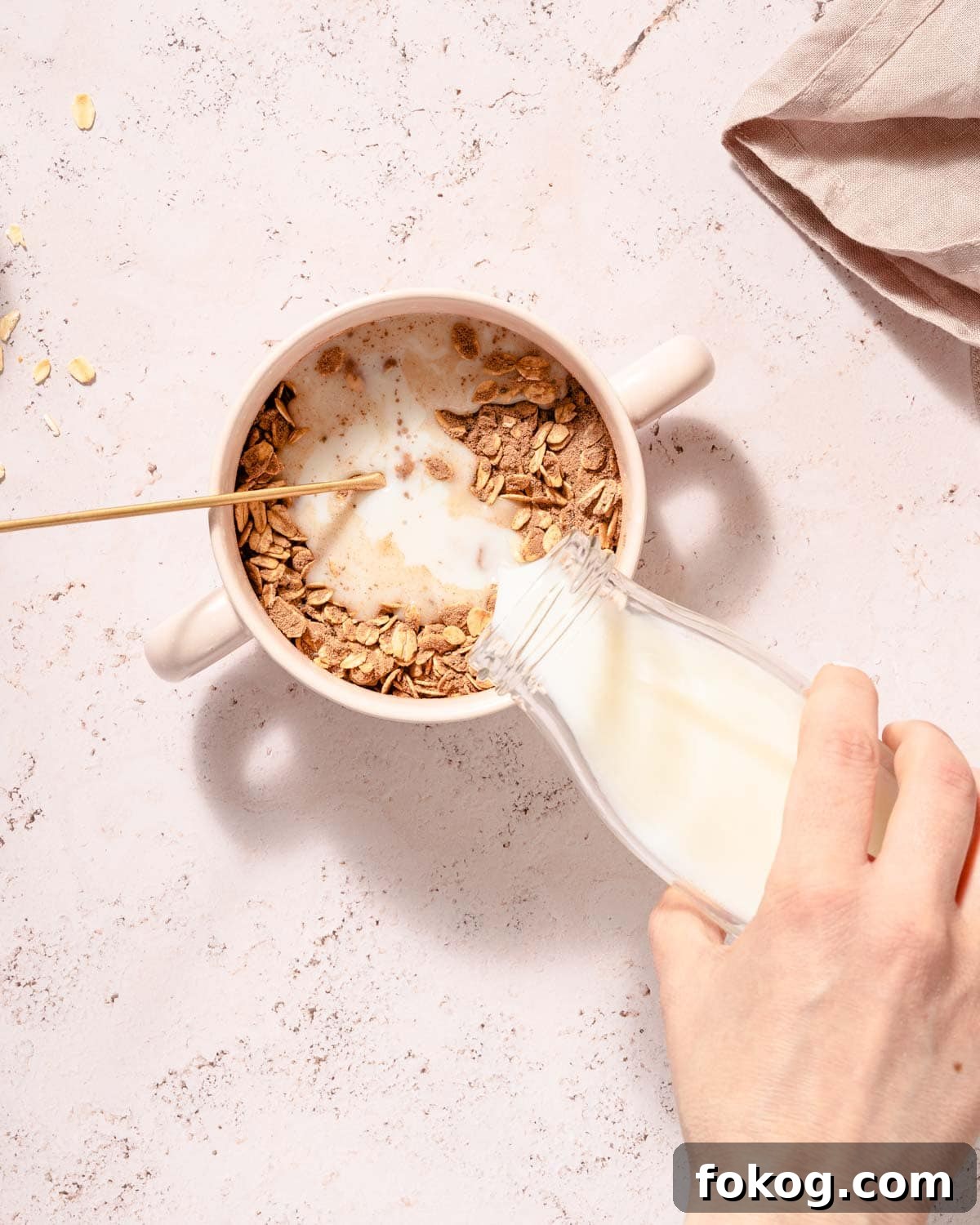 Creamy Chocolate Protein Overnight Oats 5 milk being poured into dry ingredients for chocolate protein overnight oats.