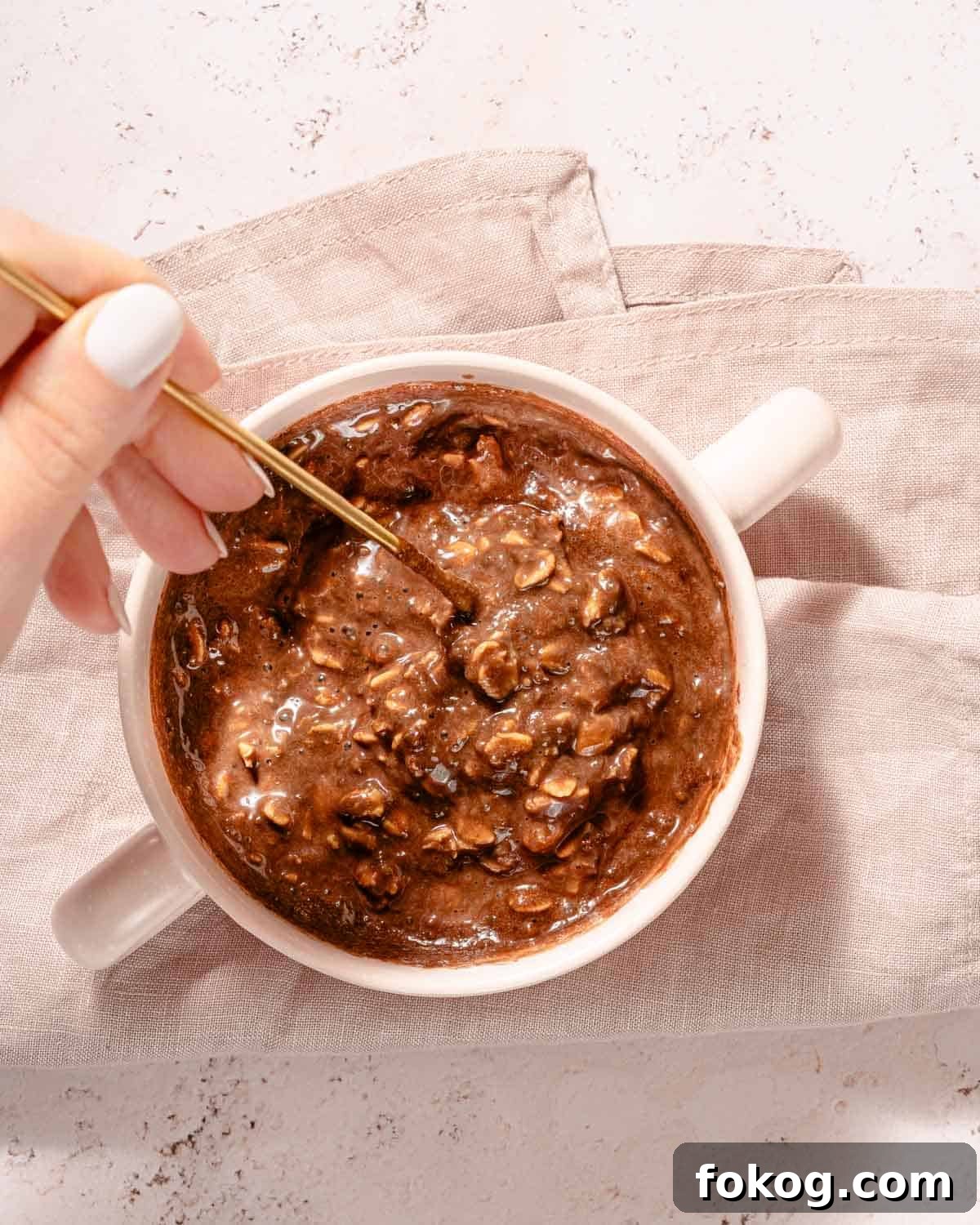 Creamy Chocolate Protein Overnight Oats 7 overnight oats being stirred with spoon after soaking overnight.
