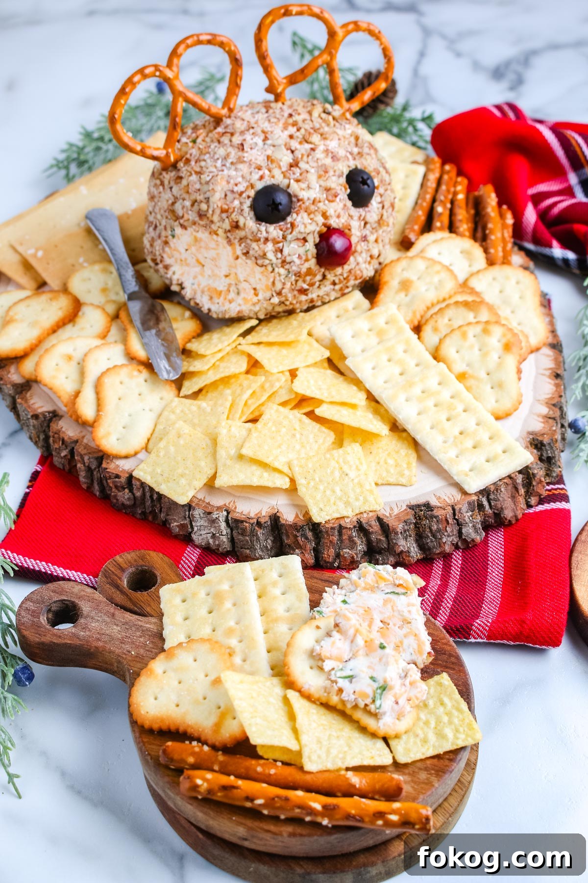 The reindeer cheese ball on a serving platter surrounded by crackers.
