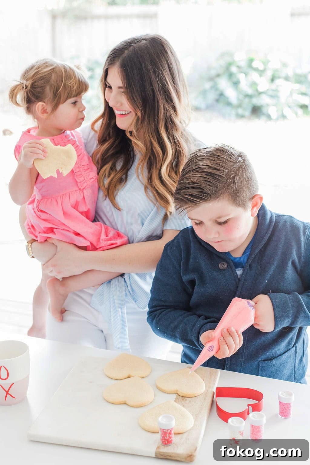 Mom and children decorating cookies.