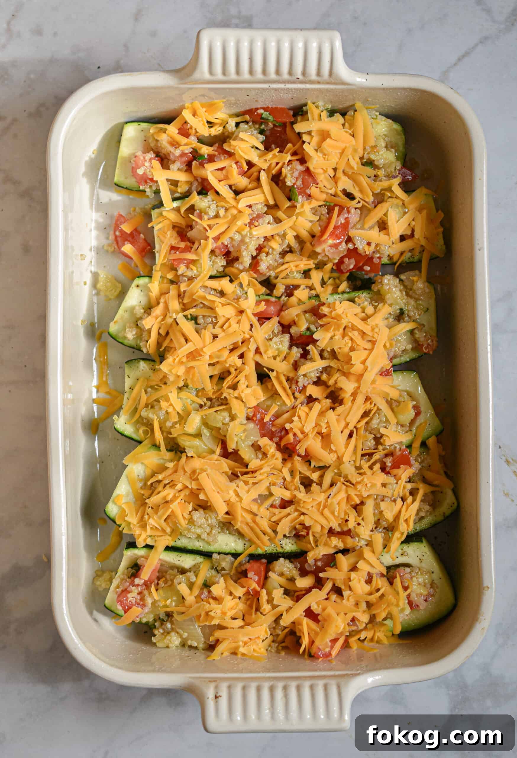 Quinoa-Stuffed Zucchini Boats with Herbs and Lemon 9 top with shredded cheese