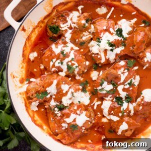 Crispy Buffalo Chicken Thighs Recipe for Dinner 8 buffalo chicken thighs in a skillet surrounded by fresh parsley, a serving utensil, and a kitchen towel