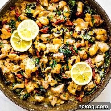 Creamy Garlic Chicken Skillet: One-Pan Dinner Recipe 2 creamy garlic chicken in a pan with lemons sliced on top