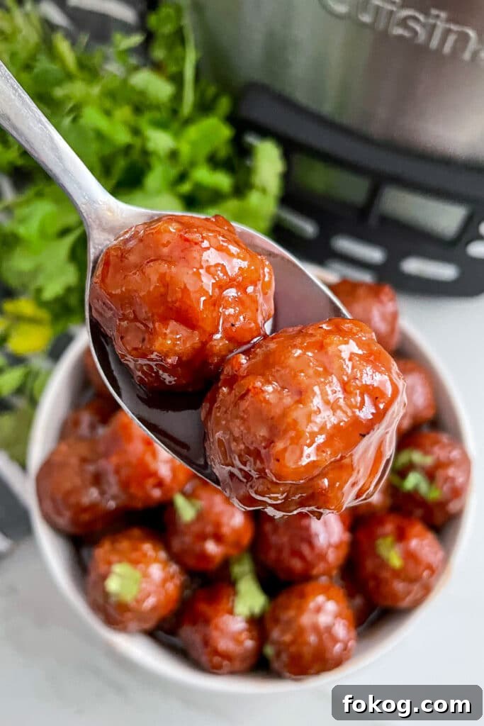 grape jelly meatballs on a serving spoon