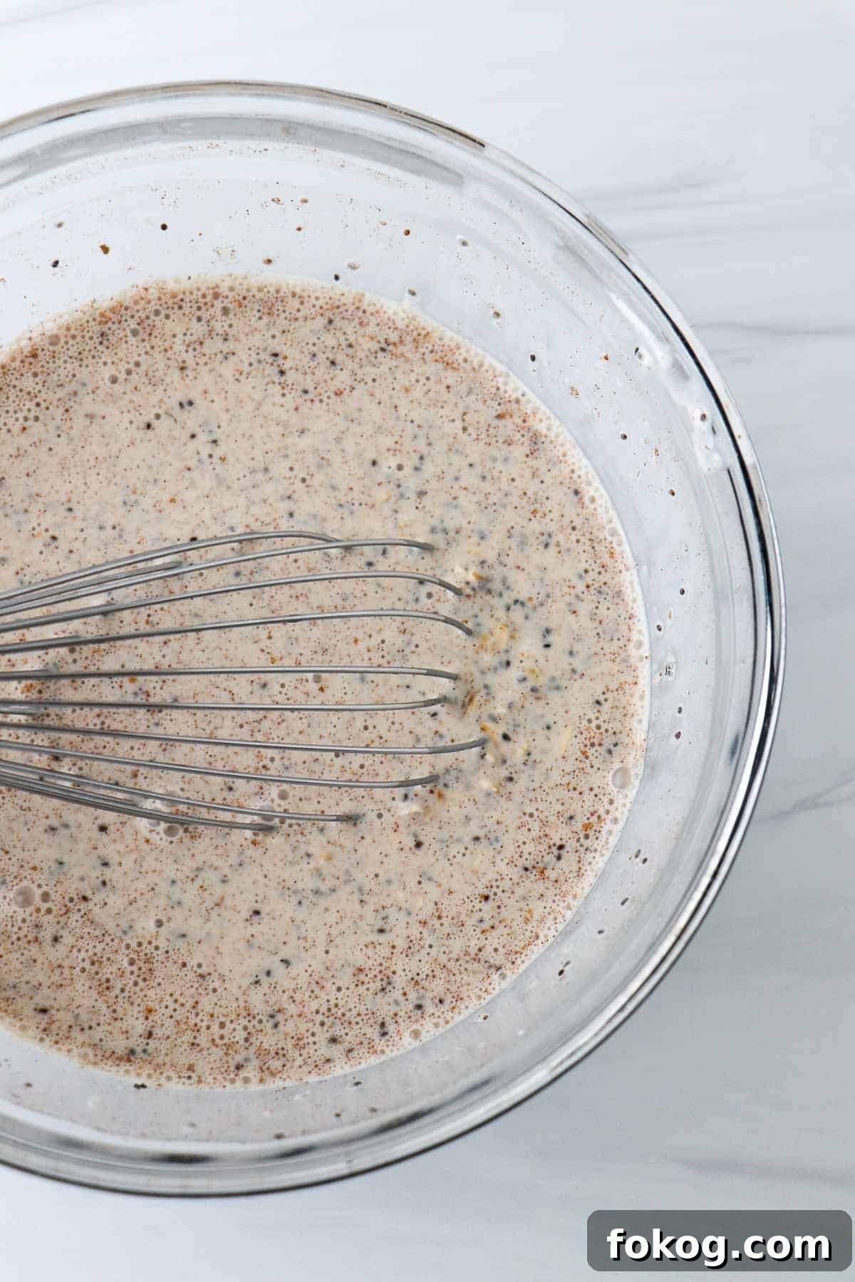 Creamy Vanilla Cinnamon Overnight Oats Recipe 4 Overnight oats in a glass bowl with a a whisk.