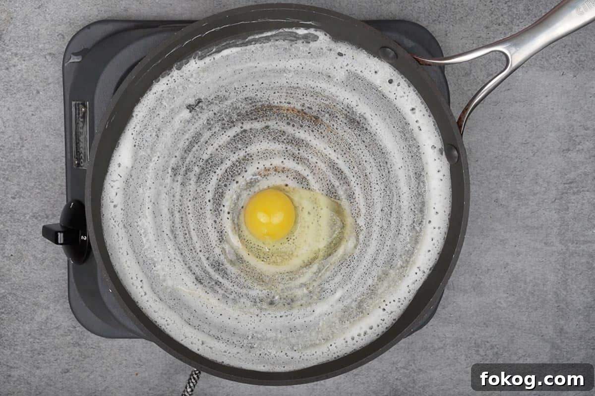 Crispy Egg Dosa (Mutta Dosa) Recipe for Perfect Breakfast 6 Egg broken on the center of the dosa.