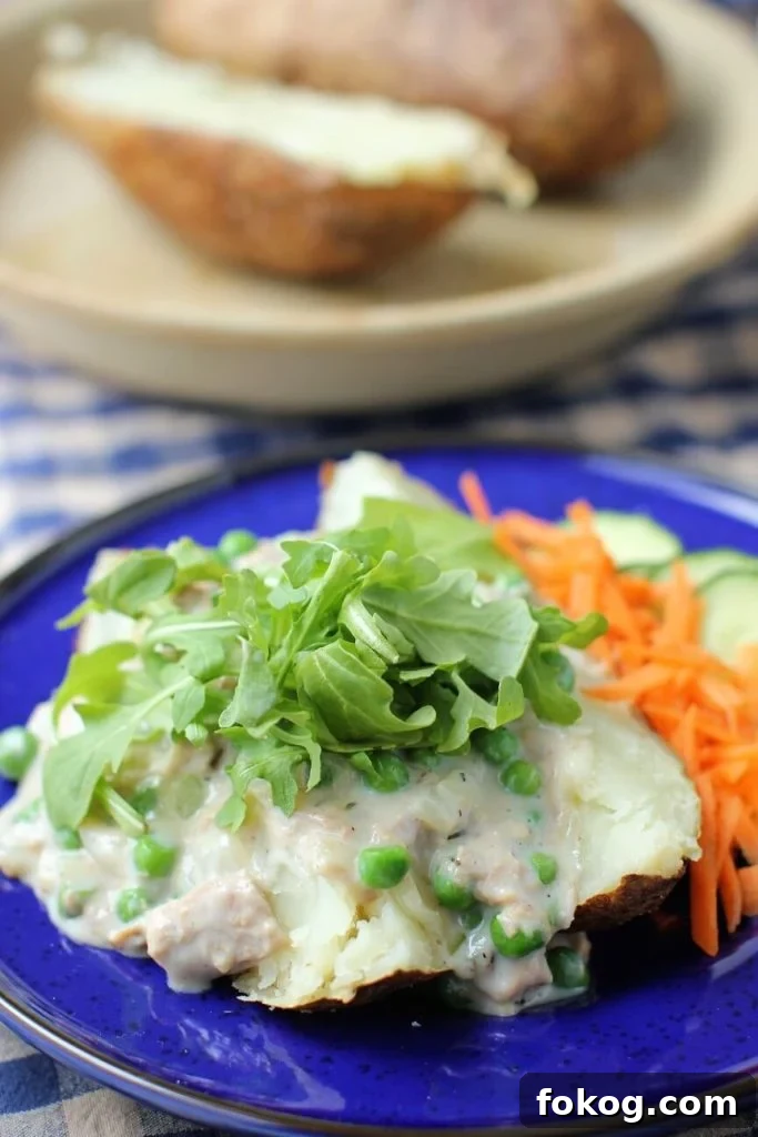 Creamy Tuna Stuffed Baked Potatoes + 44 Savory Topping Ideas 3 creamed tuna is served on top of a baked potato and topped with fresh arugula