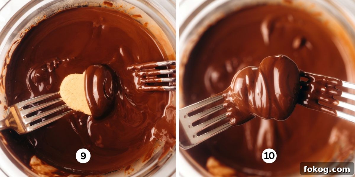 Dipping the chilled peanut butter hearts into melted chocolate in a glass bowl.