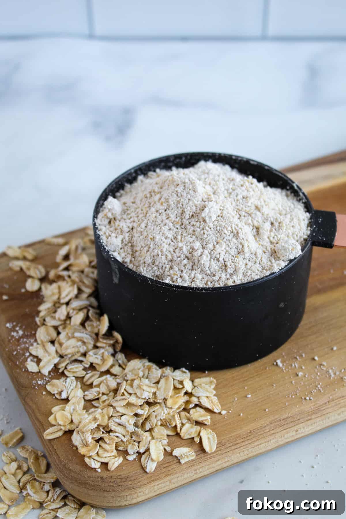 black cup of oat flour on a cutting board