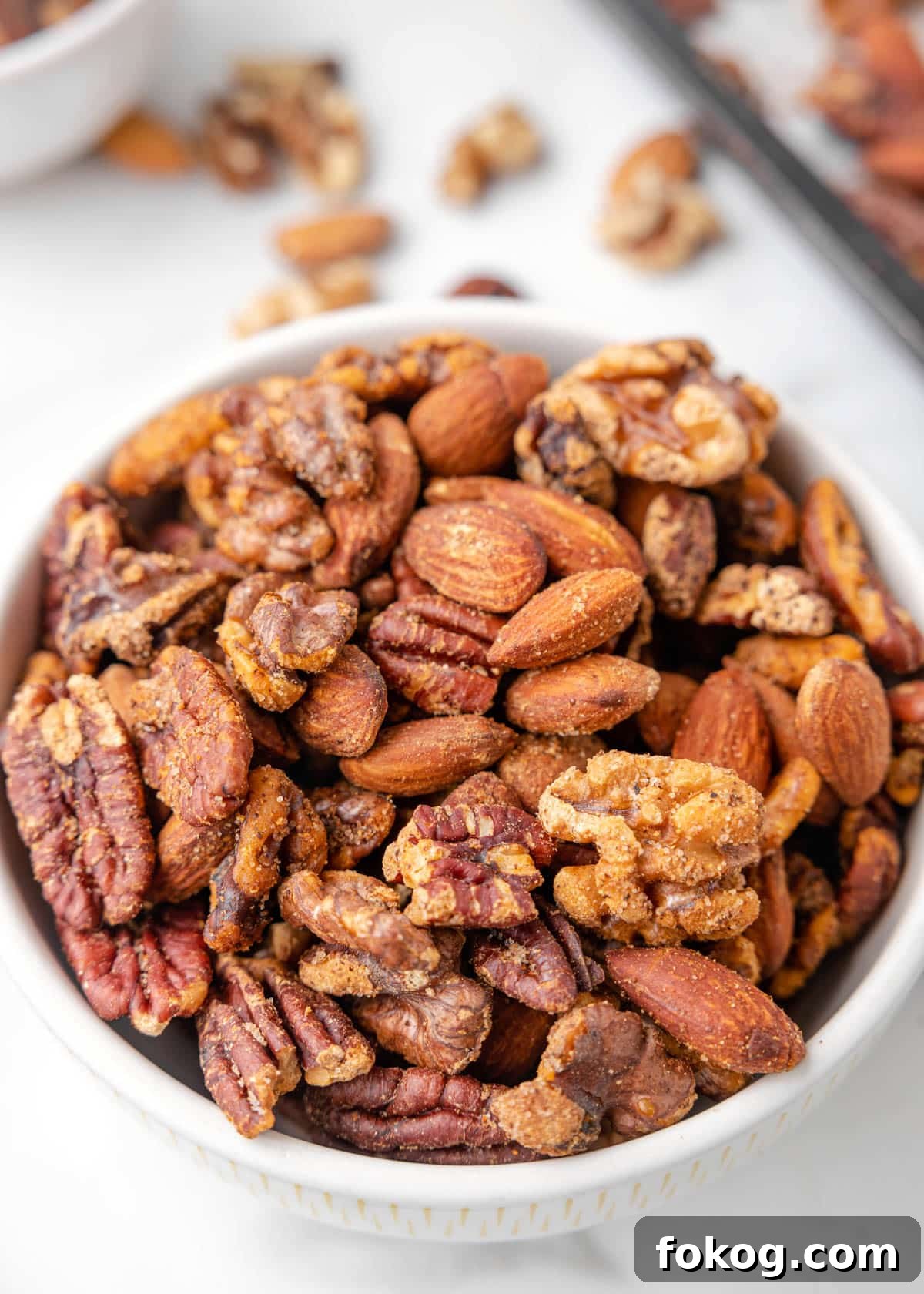 cajun spiced nut mix in a white bowl on a marble board