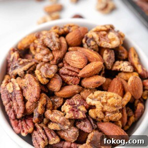cajun spiced nut mix in a white bowl on a marble board