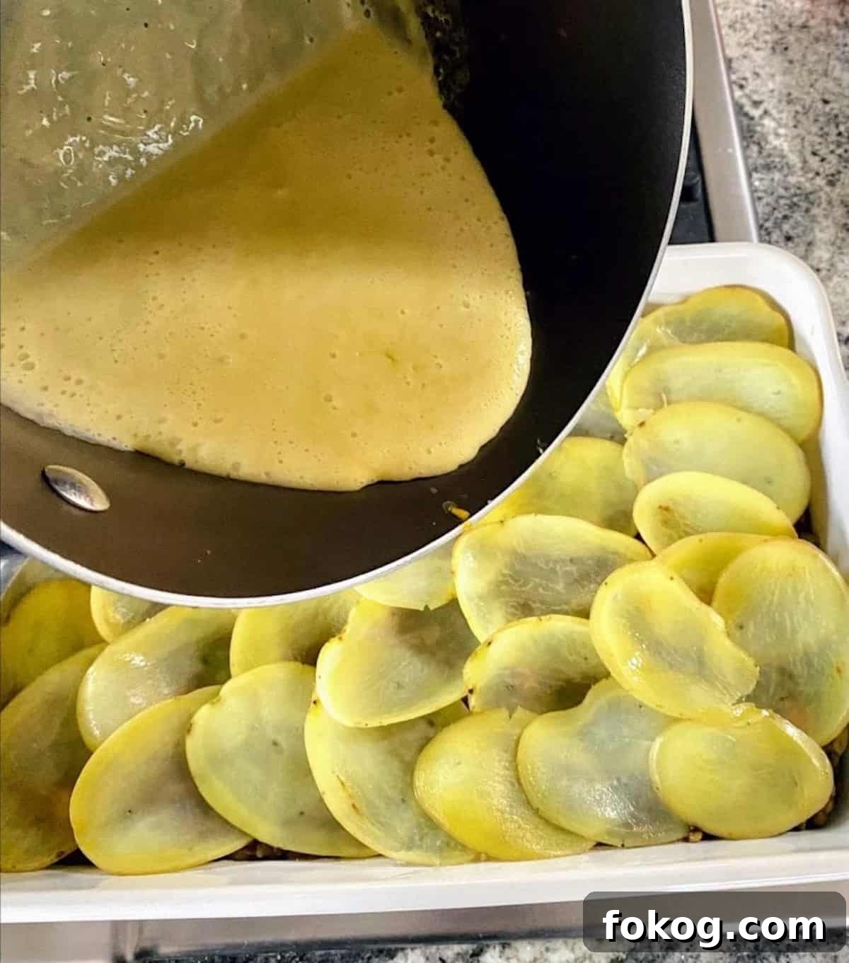 Hearty Vegan Shepherd's Pie Recipe for Comforting Weeknight Dinner 10 I am pouring the vegan cheese sauce on top of the layered blanched potatoes in the pan.