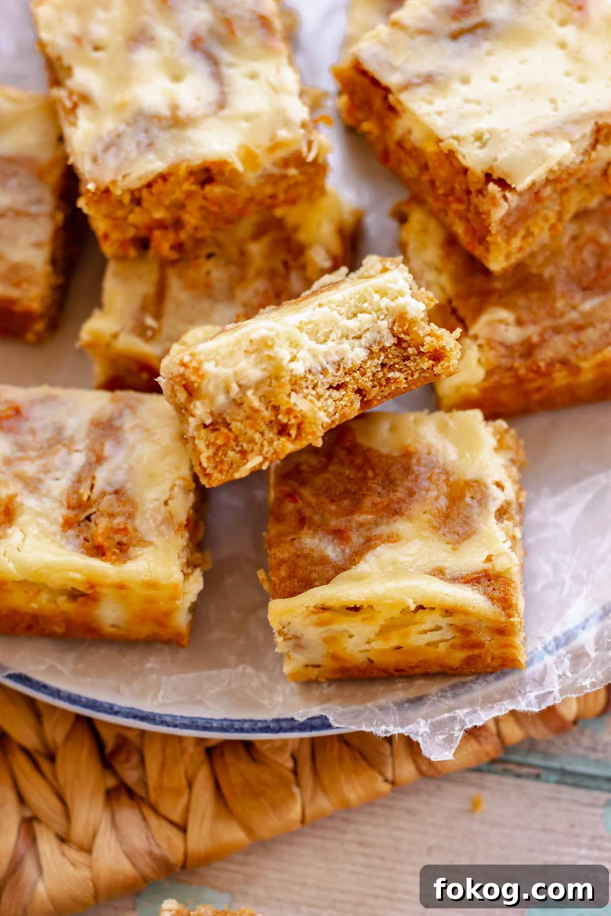 A bite removed from a carrot cake bar stacked on each other.