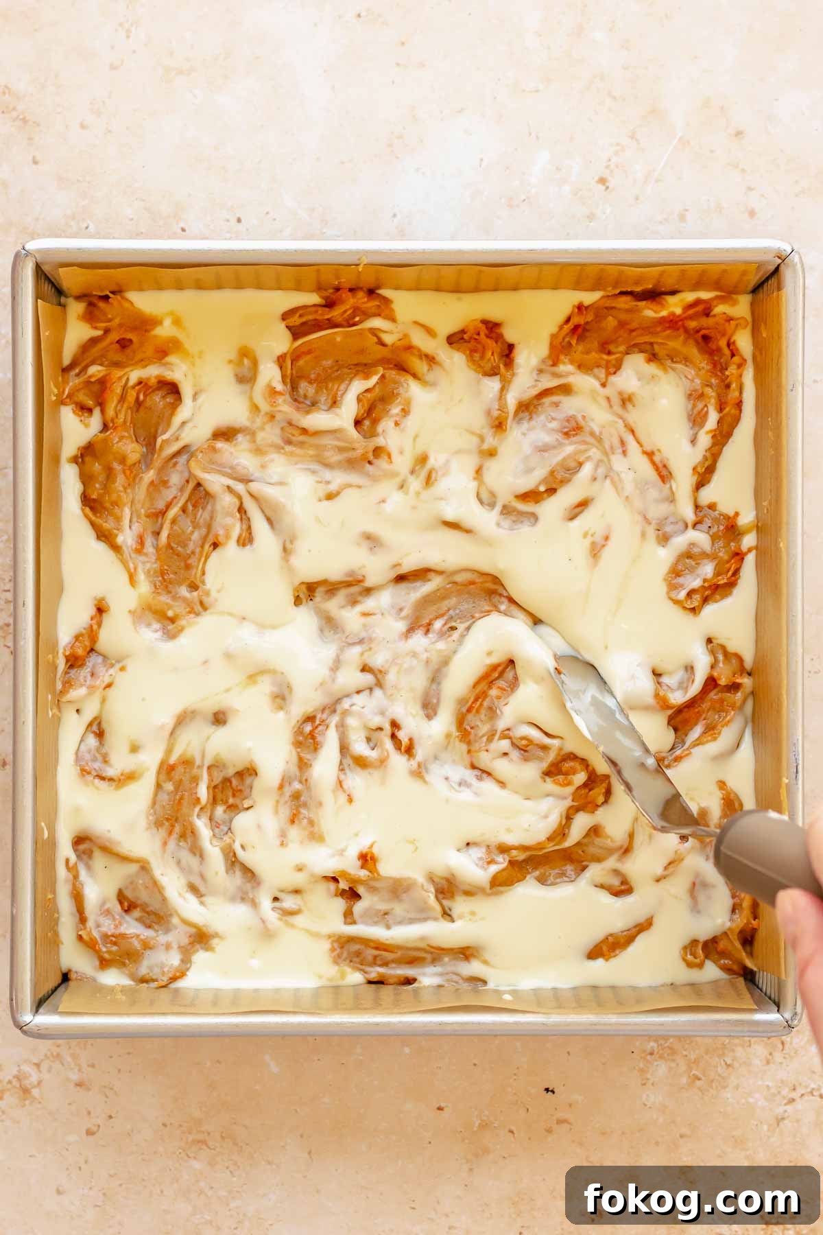 A knife swirls the batters together in the pan.