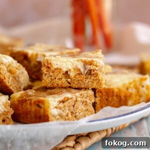 Carrot cake blondies stacked on a plate.