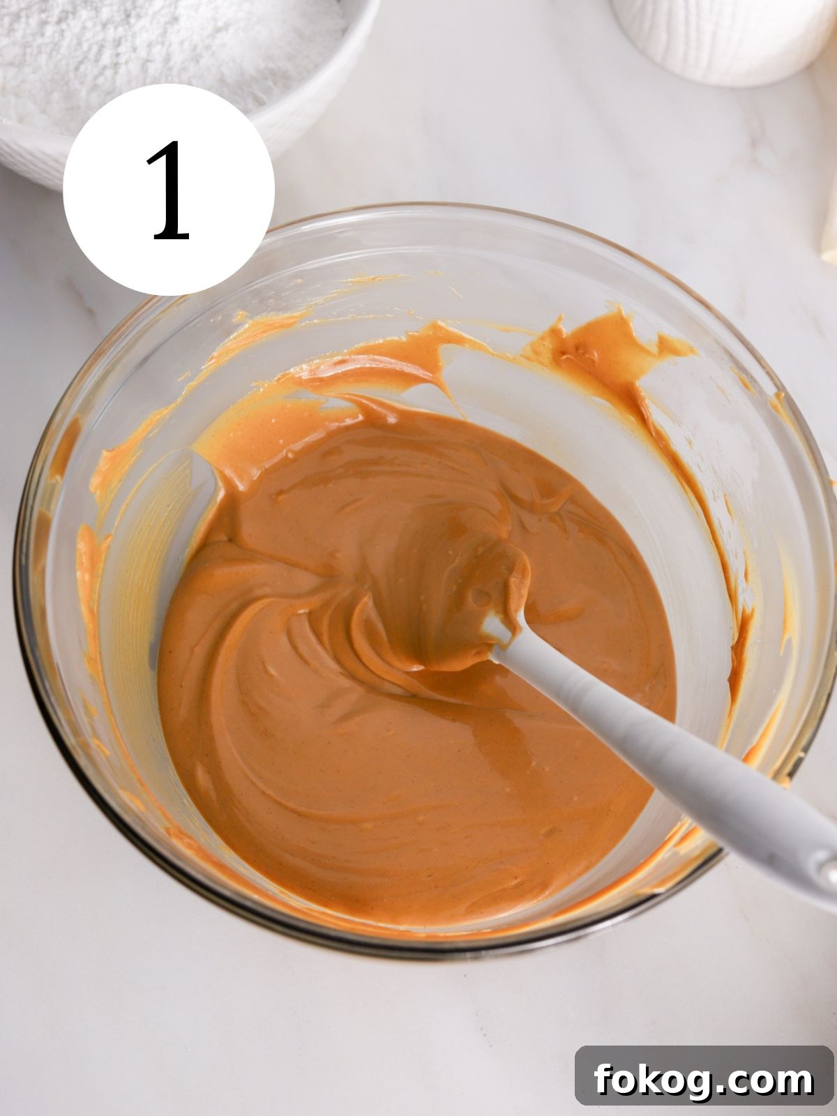 No-Bake Peanut Butter Balls Recipe: Quick Treats for Parties 4 Melted chocolate and peanut butter in a glass bowl with a spatula.