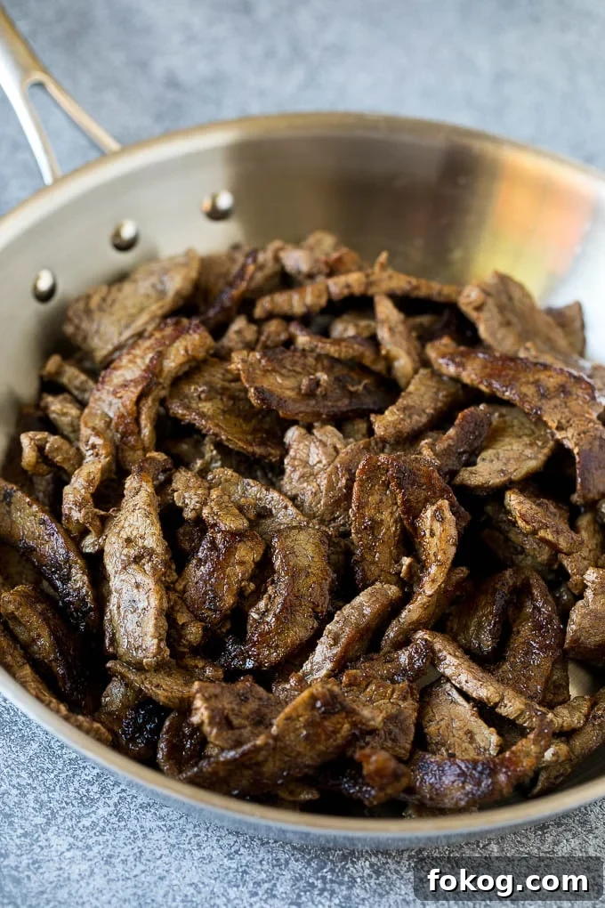 Hunan Beef Recipe | Beef Stir Fry Thinly sliced steak in a pan.