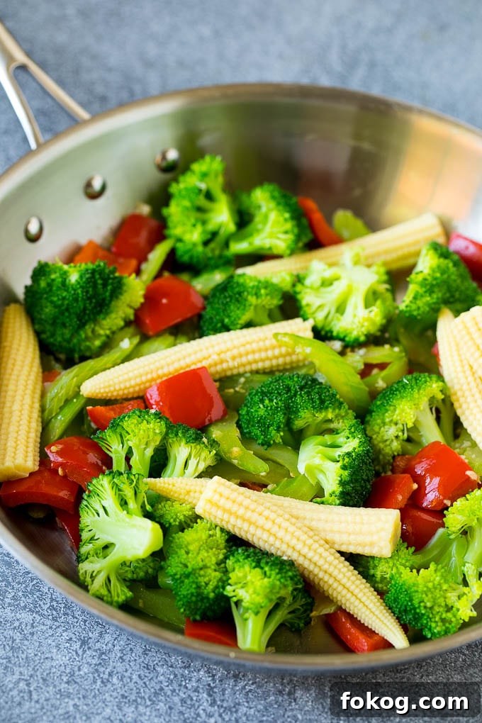 Hunan Beef Recipe | Beef Stir Fry Broccoli, baby corn, bell peppers and celery in a skillet.