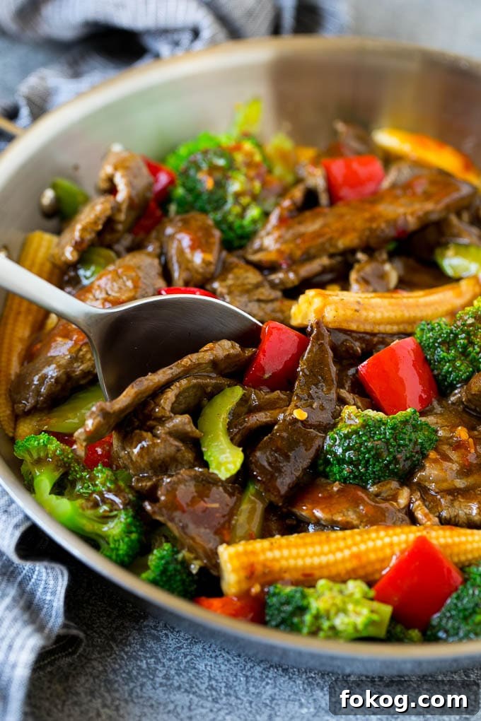 Hunan Beef Recipe | Beef Stir Fry A serving spoon in a pan full of Hunan beef.