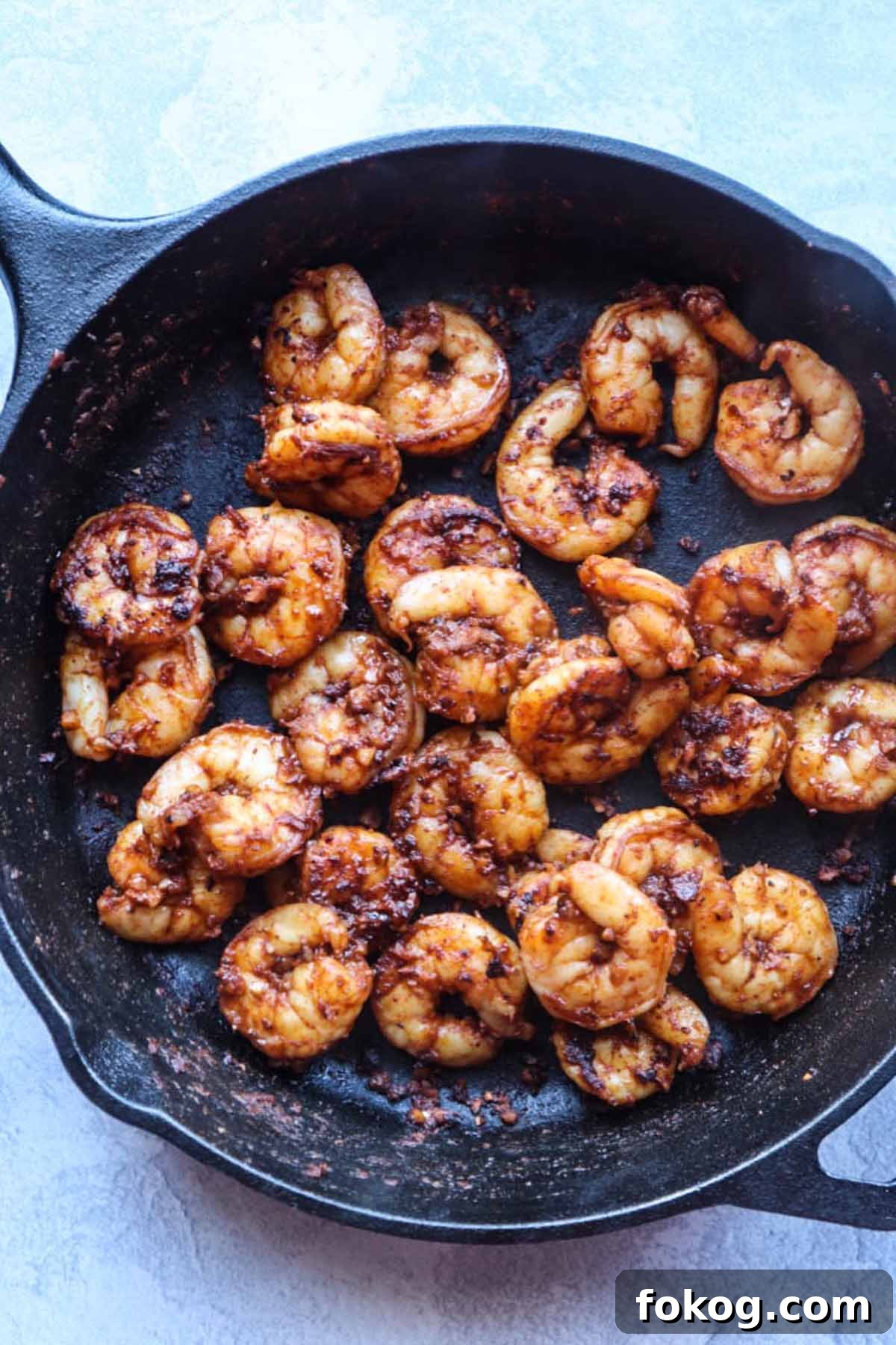 cast iron skillet with seasoned and cooked shrimp