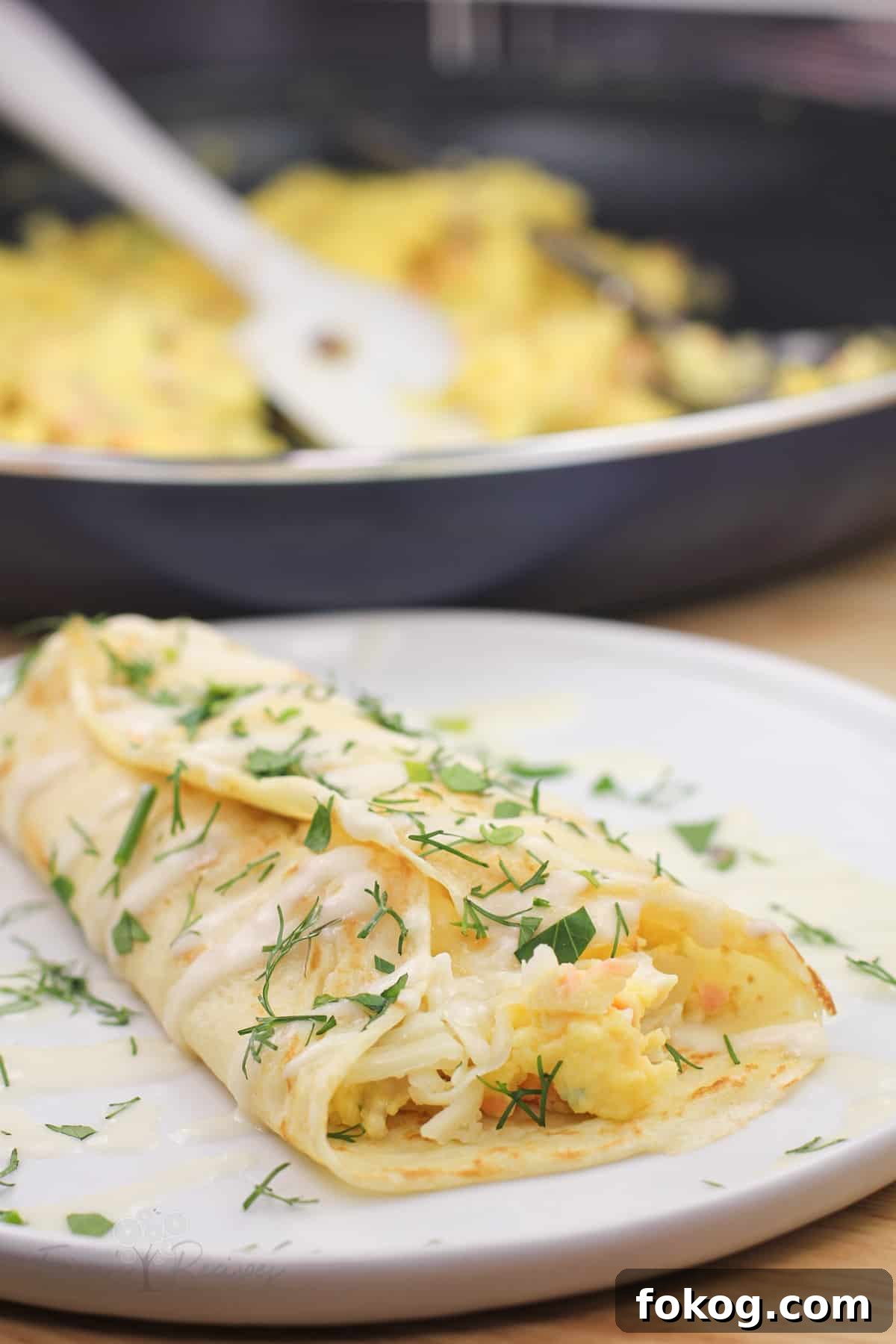 Smoked Salmon Crepes Recipe with Creamy Dill Filling 14 prepared crepe on white plate with skillet in background