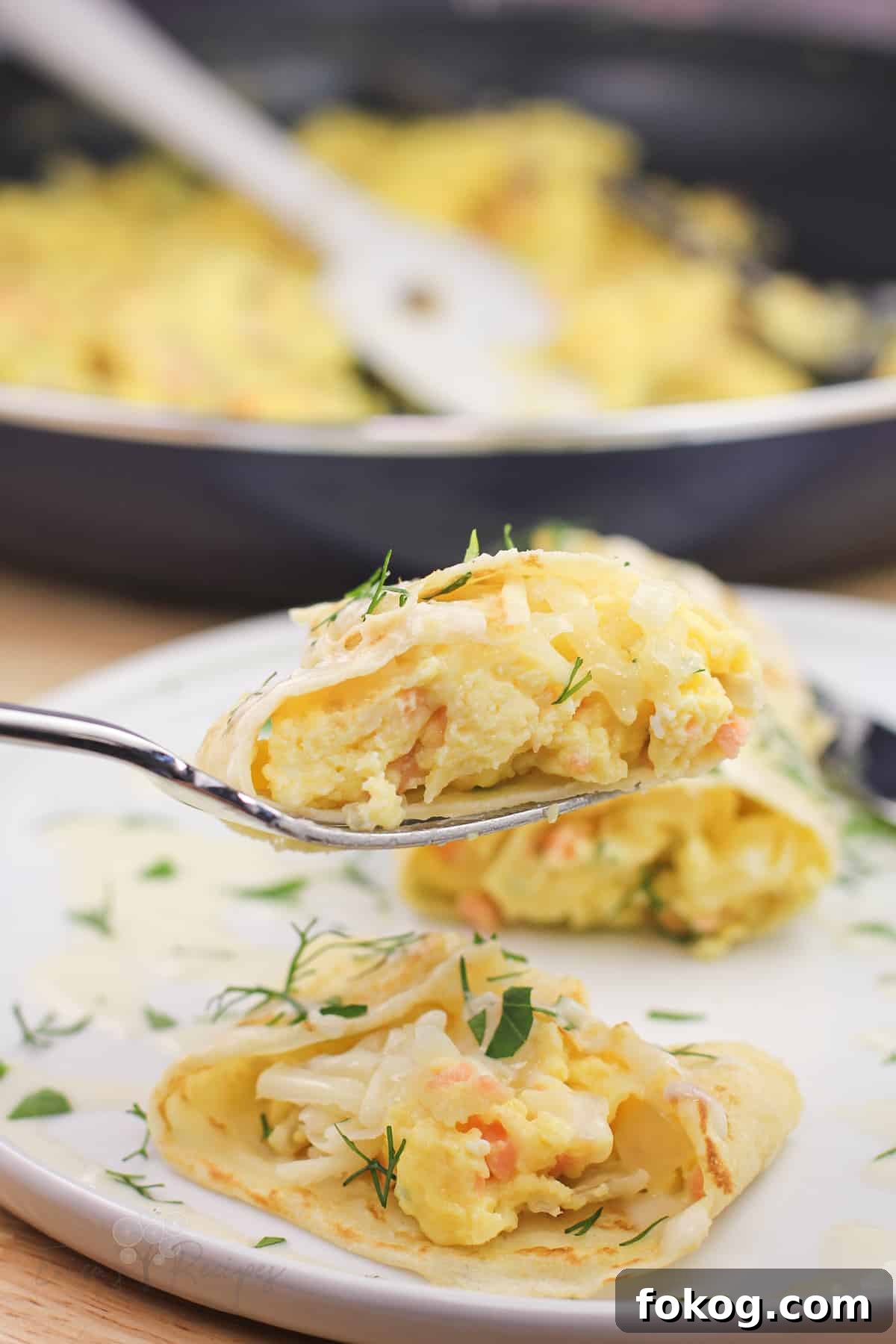 Smoked Salmon Crepes Recipe with Creamy Dill Filling 3 fork holding a bite of crepe to show the egg filling