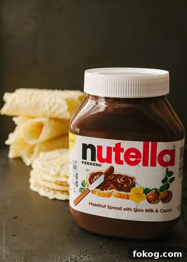 Nutella and Berry-Filled Pizzelle Waffle Cookies 5 A jar of Nutella with pizzelle in the background.