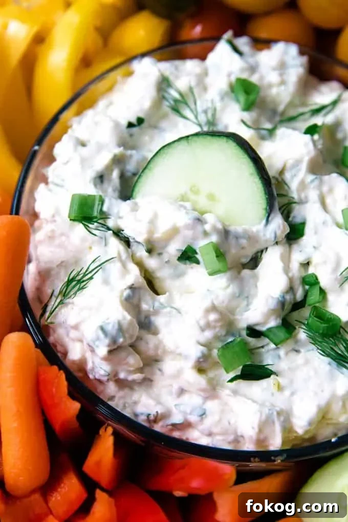 bowl of veggie dip with a cucumber slice