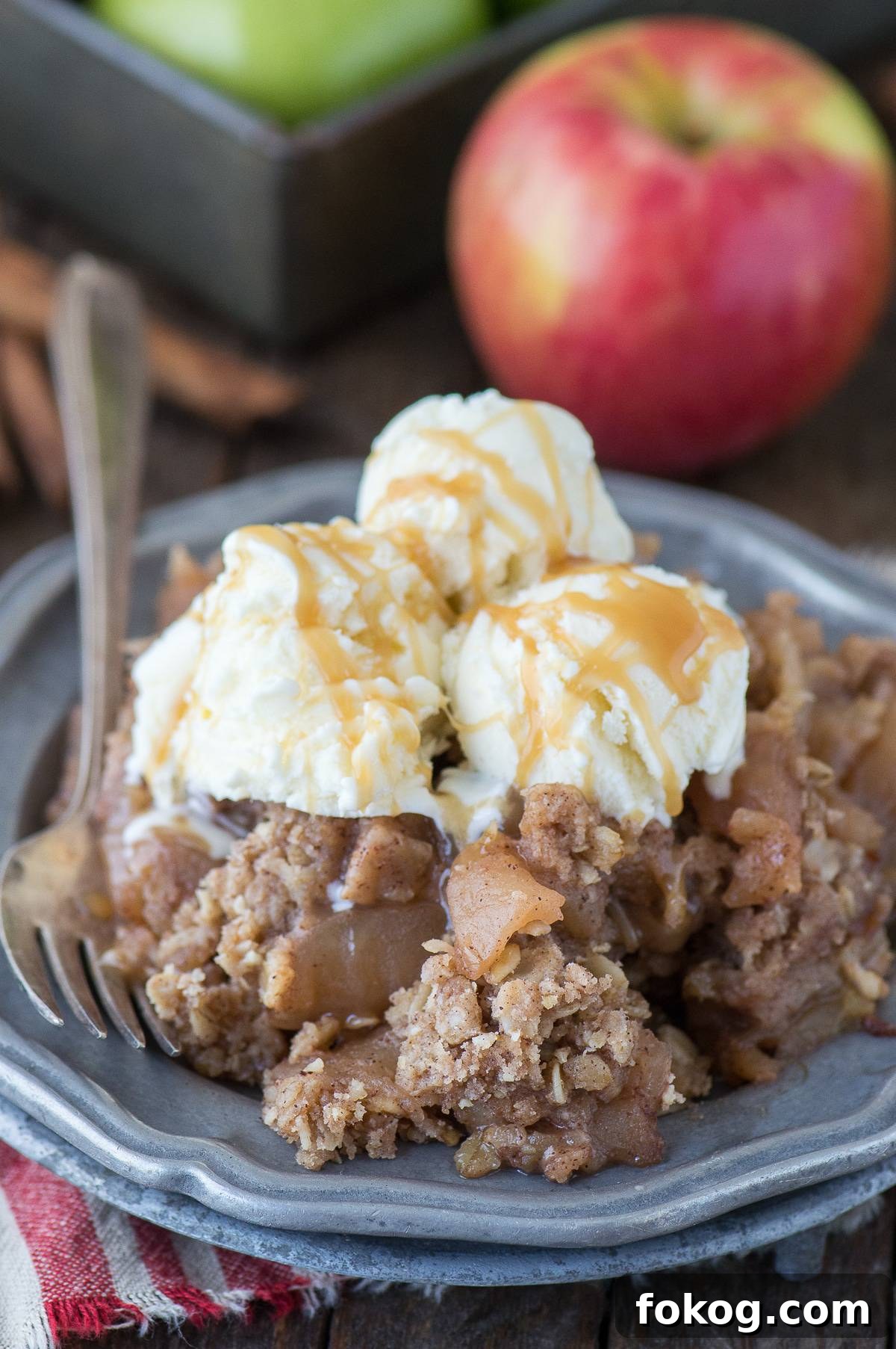 Slow-Cooker Apple Crisp with Cinnamon Oat Topping 6 scoop of crock pot apple crisp with 3 scoops of ice cream on metal plate