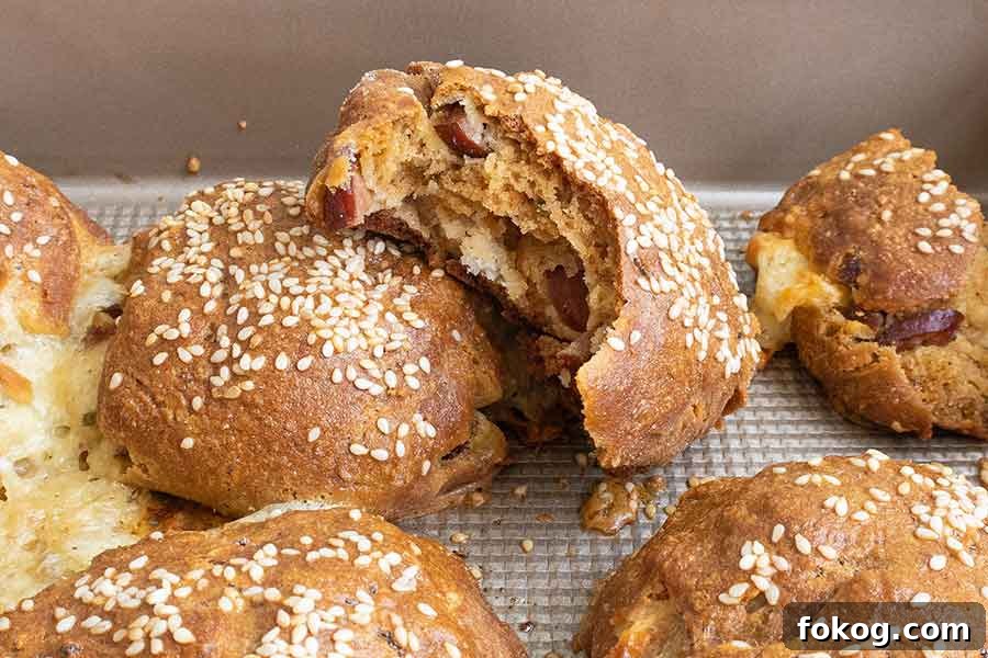 Gluten-free brioche rolls, one sliced open to reveal ham and melted mozzarella inside