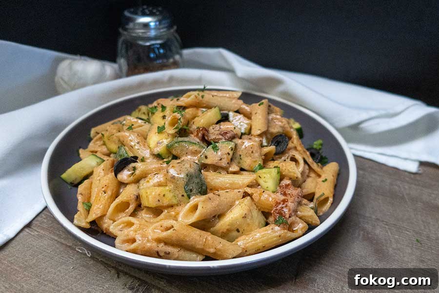 creamy tuscan pasta with zucchini in a bowl