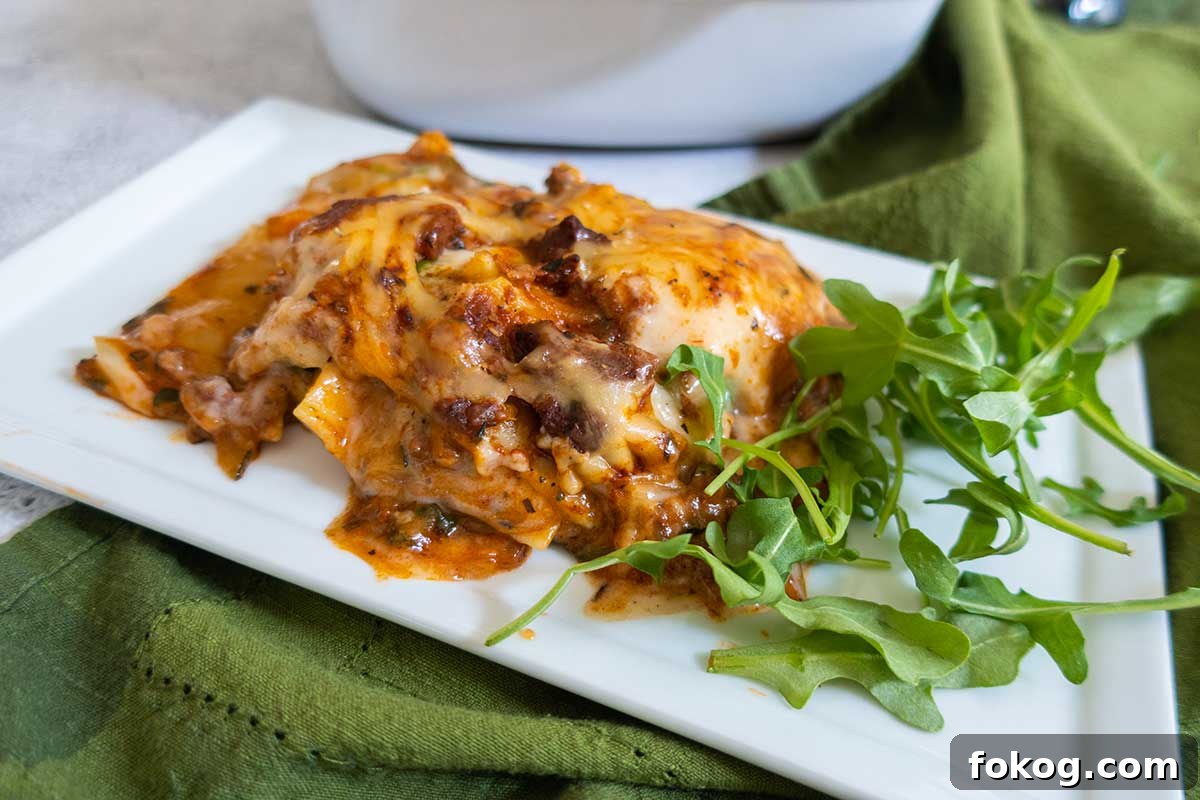 slice of dairy free creamy lasagna on a plate with fresh Basil, gluten free