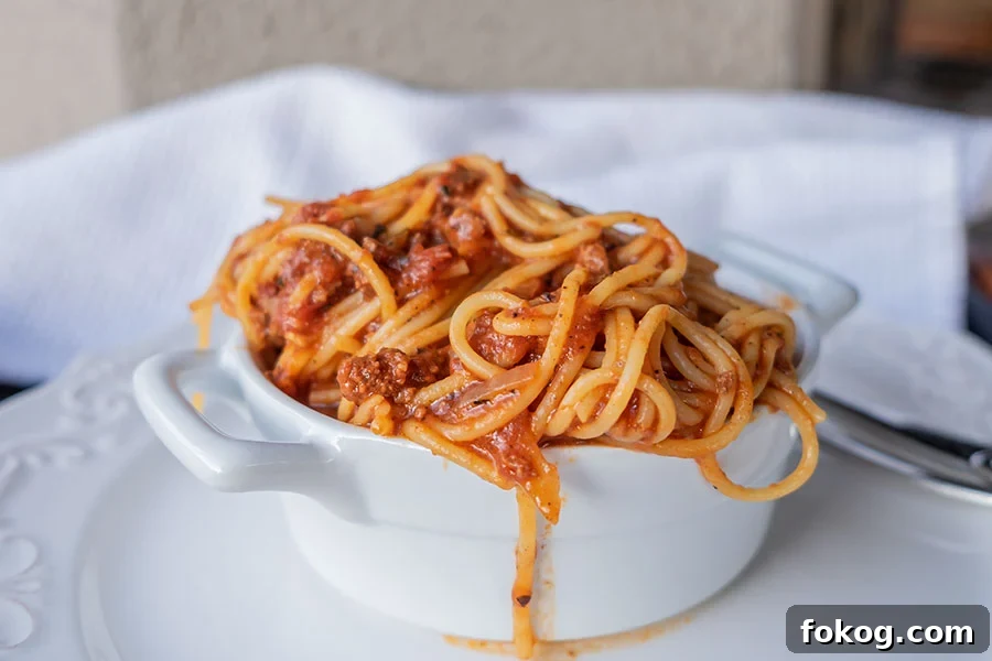 Gluten-free spaghetti Bolognese made in an Instant Pot, served in a bowl overflowing with pasta