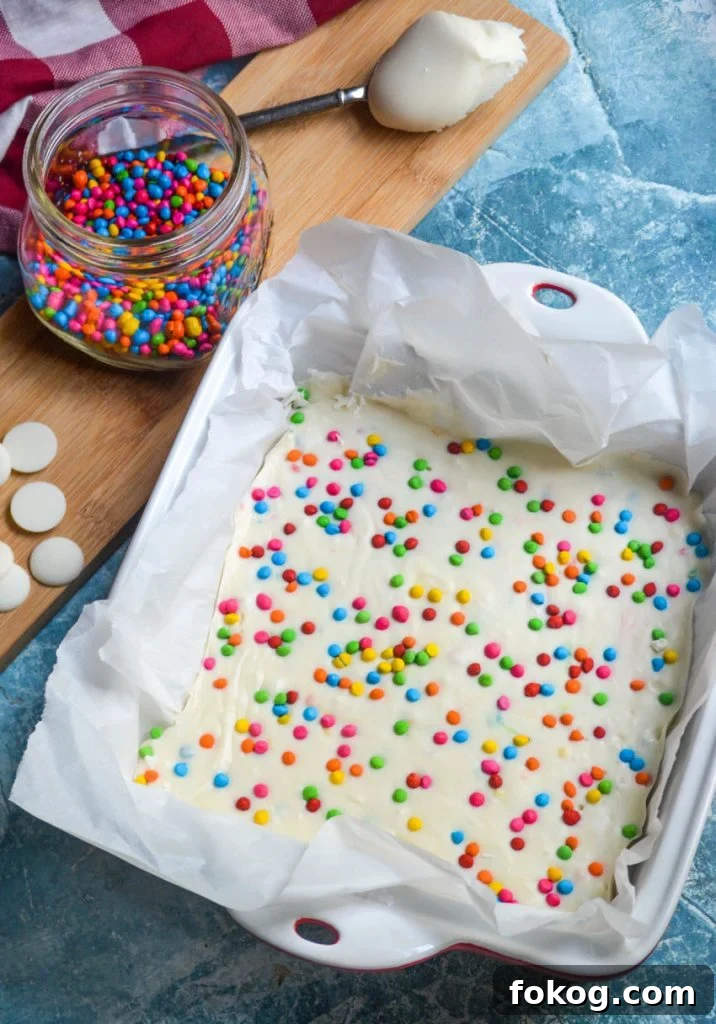 rainbow chip frosting shown in a parchment lined square baking dish