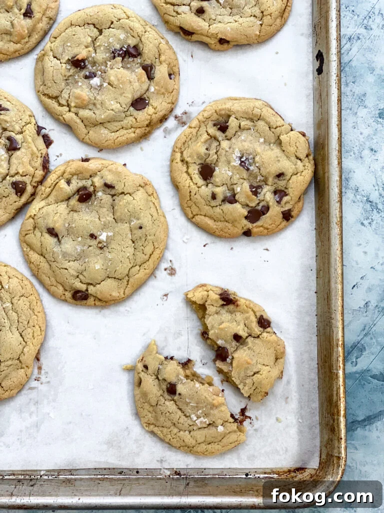 one broken cookie on a cookie sheet with others to the side