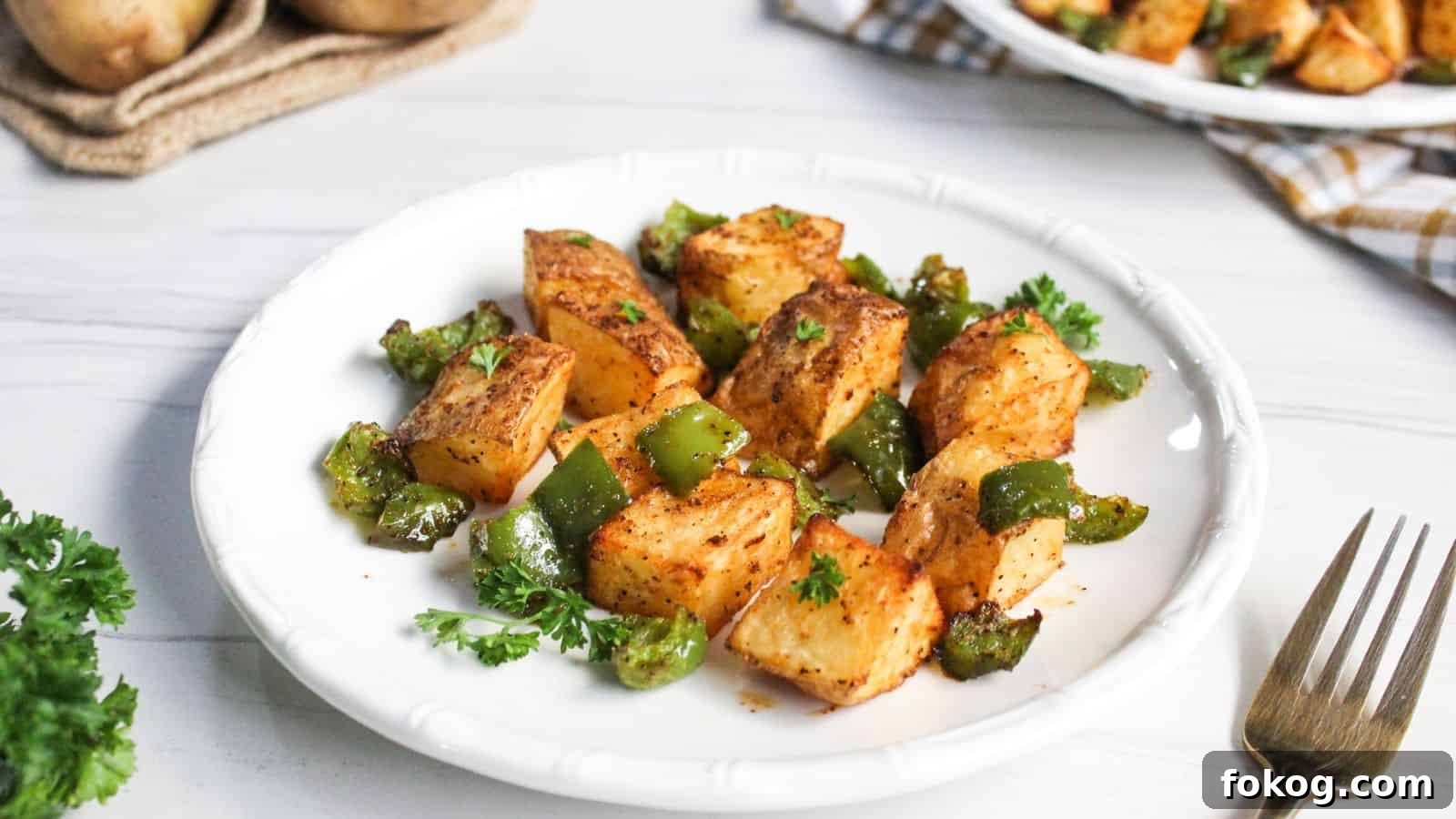 12 Irresistible Potato Recipes You’ll Love Making Again 9 Air-fried potato cubes with diced green bell peppers on plate.