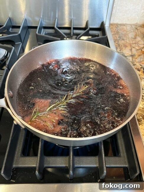 Pomegranate-Port Gravy with Rosemary for Roasts and Poultry 5 Pomegranate gravy elements reducing in a pot.