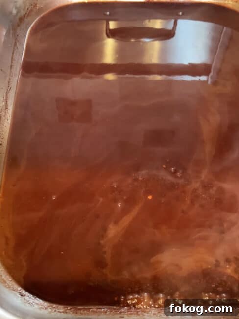 Pomegranate-Port Gravy with Rosemary for Roasts and Poultry 10 Pomegranate gravy in the roasting pan bubbling and almsot ready to go.
