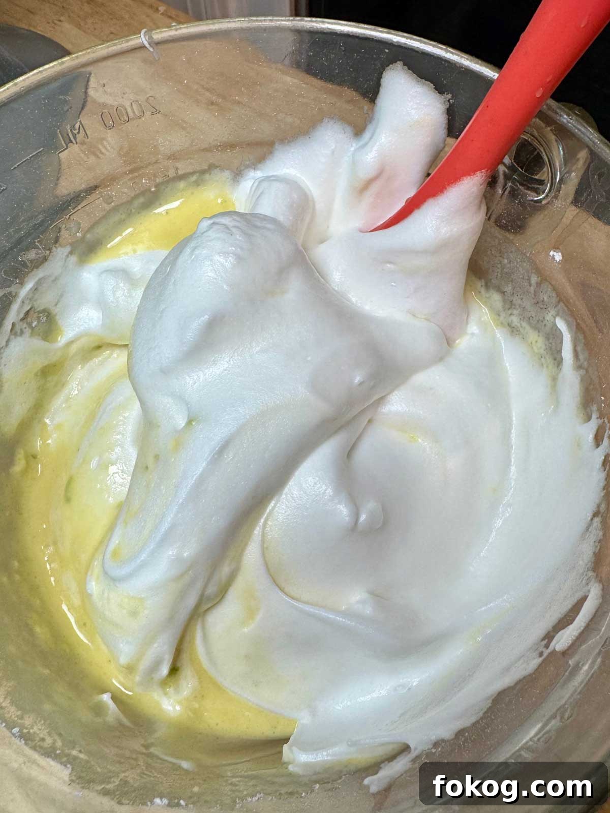 Egg whites being folded into sponge cake batter.