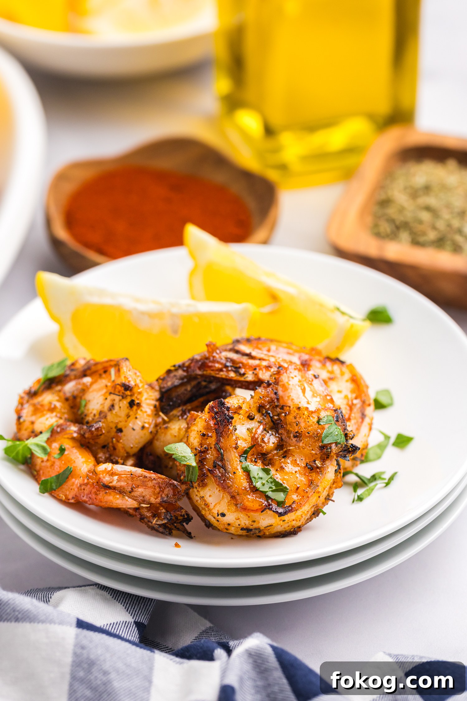 Perfect Grilled Shrimp Recipe for Juicy, Flavorful Results 2 Close-up of grilled shrimp served on a white plate with lemon wedges and garnished with chopped parsley.