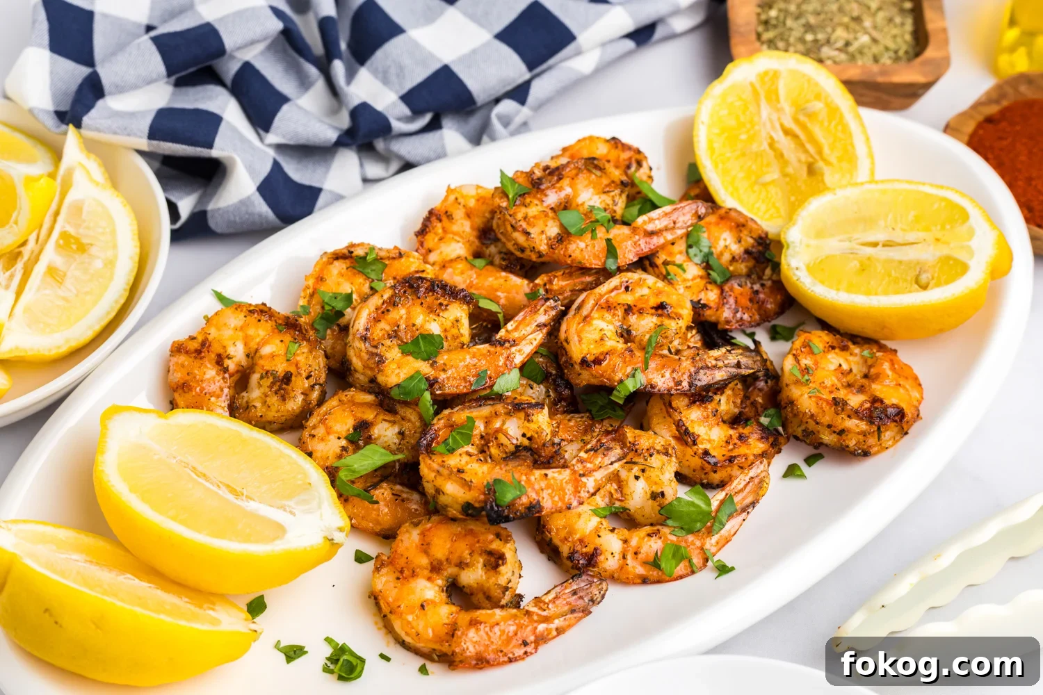 Perfect Grilled Shrimp Recipe for Juicy, Flavorful Results 10 Final plated presentation of grilled shrimp on a white platter, garnished with fresh parsley and surrounded by lemon wedges.