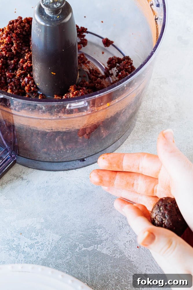 Cranberry Orange Chocolate Hemp Energy Bites 7 Chocolate energy balls being rolled with hands