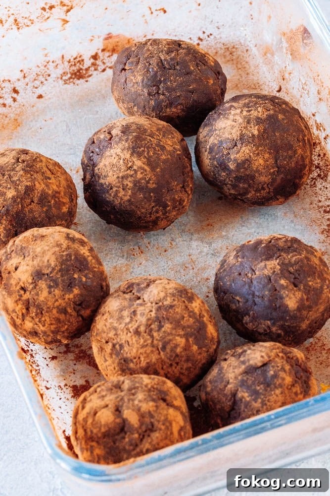 Cranberry Orange Chocolate Hemp Energy Bites 8 Chocolate energy balls being tossed in cocoa powder
