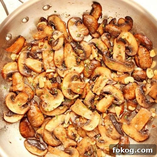 Sauteed mushrooms in a stainless steel skillet.