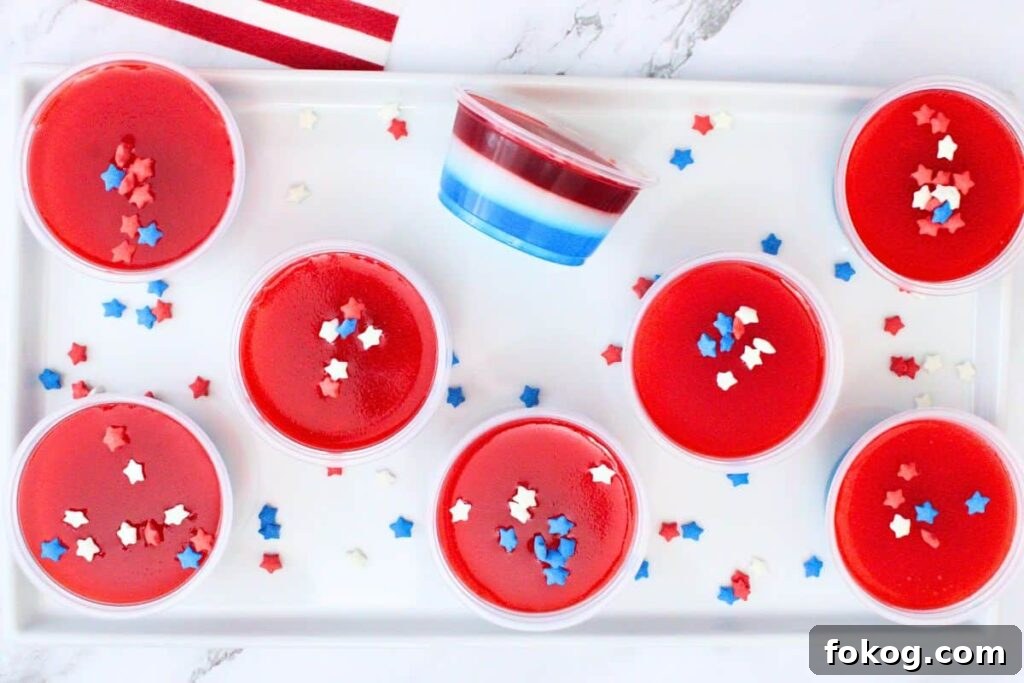 overhead view of red white and blue jello shots with one tipped on the side to show layers