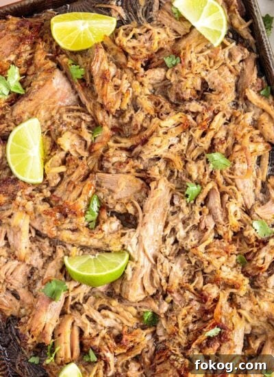 Mojo Pork slow cooker shredded and ready to eat, garnished with lime.