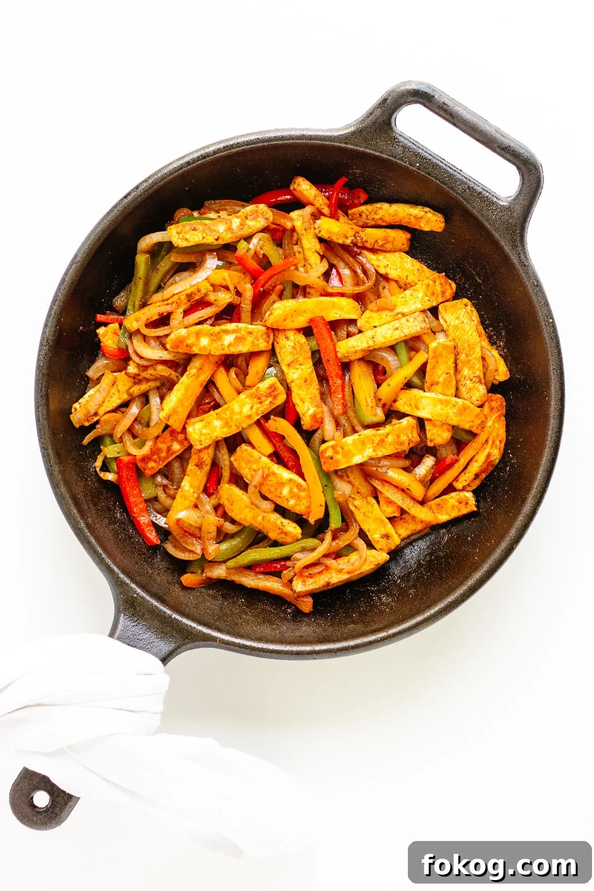 Grilled Halloumi Fajitas with Peppers and Lime crema 11 Fajita veggies with pan fried halloumi strips in a cast iron skillet.