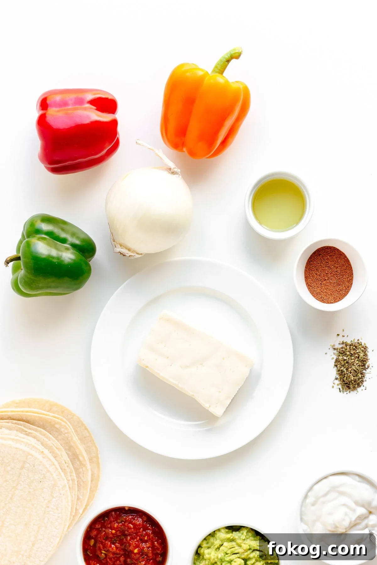 Grilled Halloumi Fajitas with Peppers and Lime crema 4 Flat lay of ingredients needed to make halloumi fajitas on a white background.