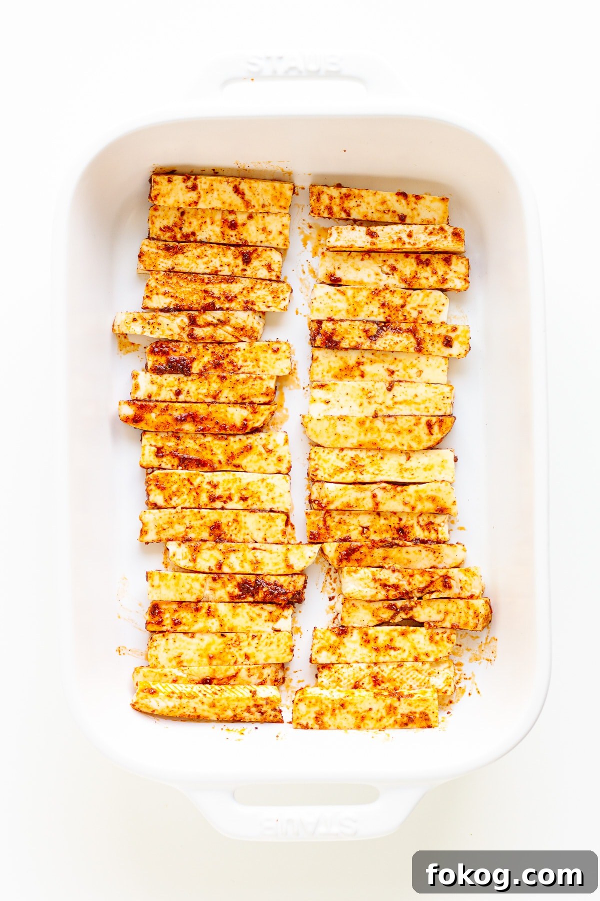 Grilled Halloumi Fajitas with Peppers and Lime crema 6 Seasoned halloumi strips in a white casserole dish.