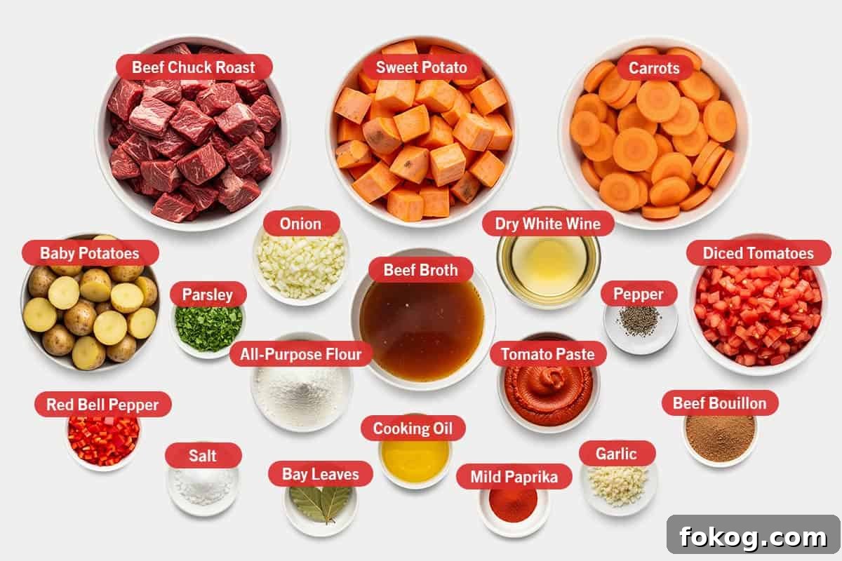 Top shot of ingredients: Beef chuck roast, sweet potato, carrots, baby potatoes, parsley, onion, beef broth, dry white wine, pepper, diced tomatoes, beef bouillon, tomato paste, all-purpose flour, red bell pepper, salt, bay leaves, cooking oil, mild paprika, and garlic.